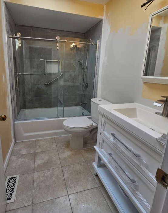 After: modern bathroom with a glass tub-shower enclosure and new vanity