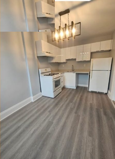 After: renovated kitchen with white cabinets, new counters, vinyl plank flooring and pendant lighting